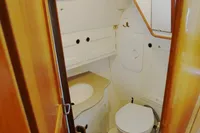 Compact boat bathroom with wooden accents, featuring a toilet and sink. CR 400 DS, 2002 model.
