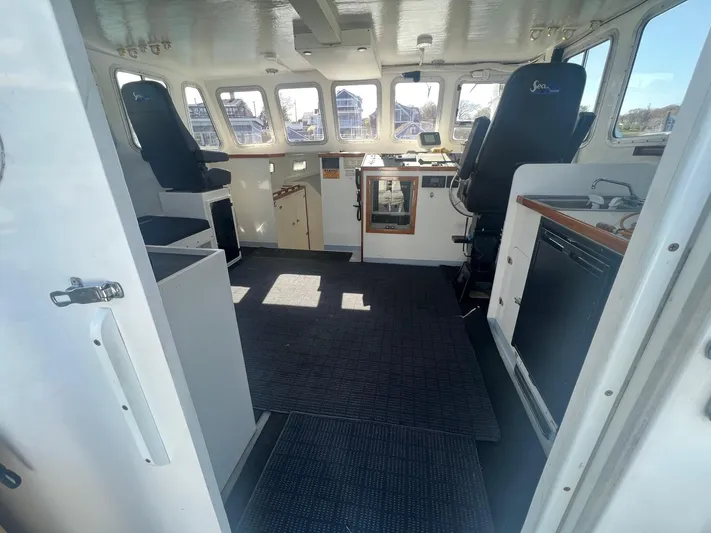  Yacht Photos Pics Interior of a 2003 H&H Marine 42 Downeast boat, featuring helm and seating area.