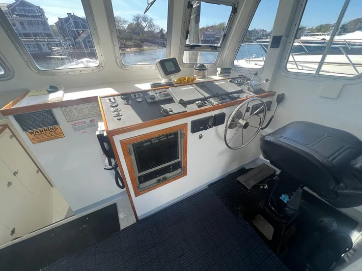  Yacht Photos Pics 2003 H&H Marine 42 Downeast boat helm with steering wheel and control panel.