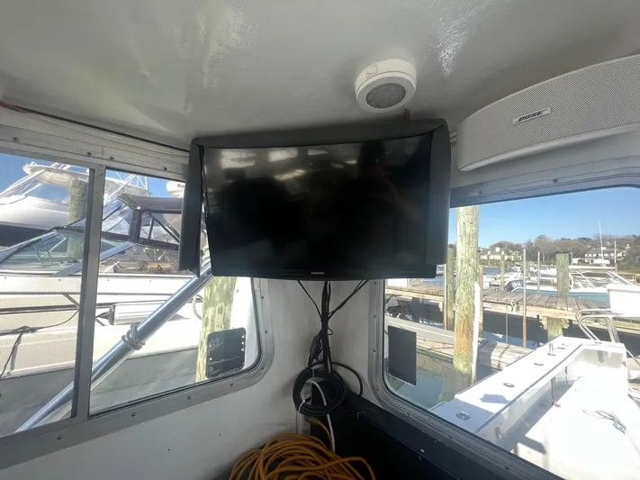  Yacht Photos Pics Interior of a 2003 H&H Marine 42 Downeast boat with mounted TV and marina view.