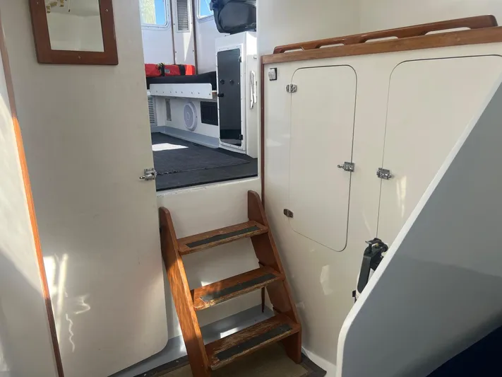  Yacht Photos Pics Interior view of 2003 H&H Marine 42 Downeast boat with wooden steps and storage cabinets.