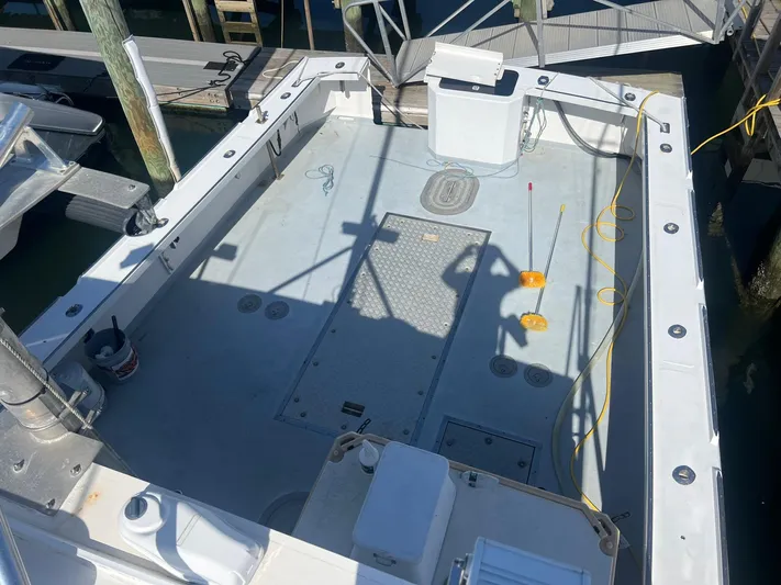  Yacht Photos Pics 2003 H&H Marine 42 Downeast boat deck, docked, with fishing equipment and storage compartments.