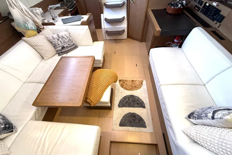 Cruzeiro Do Sul Yacht Photos Pics Luxurious interior of 2013 Jeanneau Sun Odyssey 44 DS yacht with white seating and wooden accents.