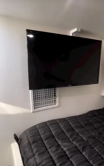 "silver Lining" Yacht Photos Pics Wall-mounted TV above bed in modern room, Flowers Down East 2022 model.