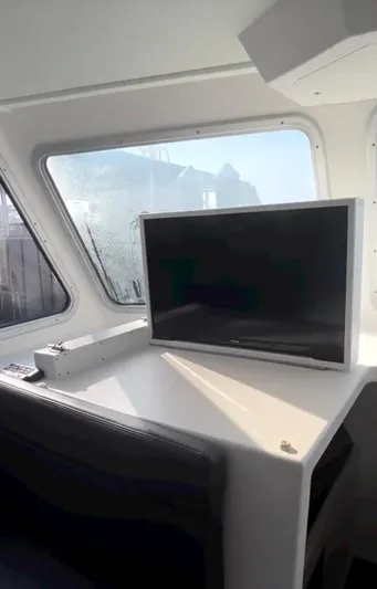 "silver Lining" Yacht Photos Pics Interior of a 2022 Flowers Down East boat with a TV and control panel.