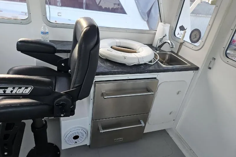 "silver Lining" Yacht Photos Pics Boat interior with black seat, countertop, sink, and life preserver, Flowers Down East 2022 model.