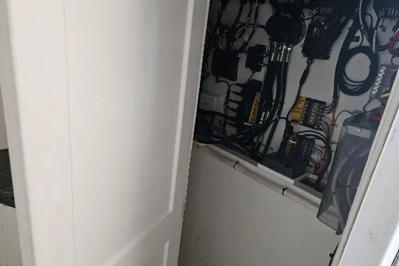 "silver Lining" Yacht Photos Pics Electrical panel with wiring inside a partially open white door, Flowers Down East 2022 model.