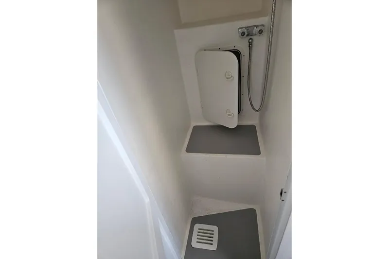 "silver Lining" Yacht Photos Pics Compact shower area in a 2022 Flowers Down East boat, featuring a small hatch and drain.