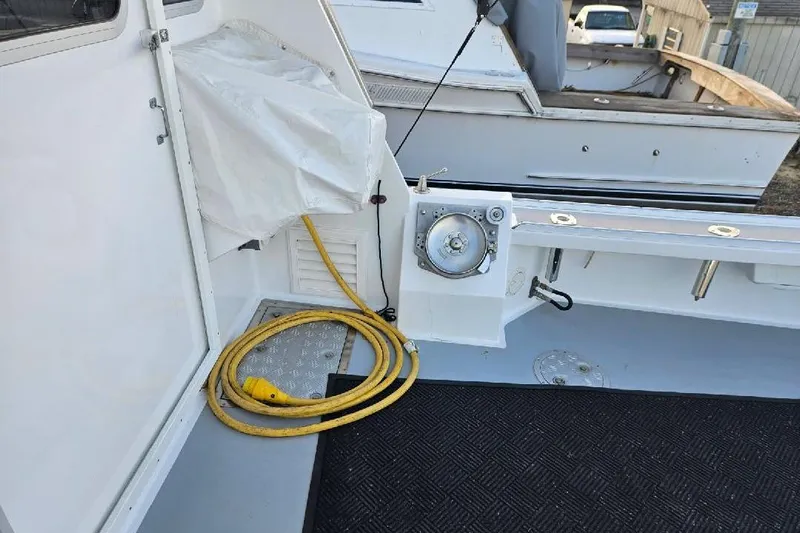 "silver Lining" Yacht Photos Pics Boat deck with coiled yellow cable, winch, and covered equipment, Flowers Down East 2022 model.
