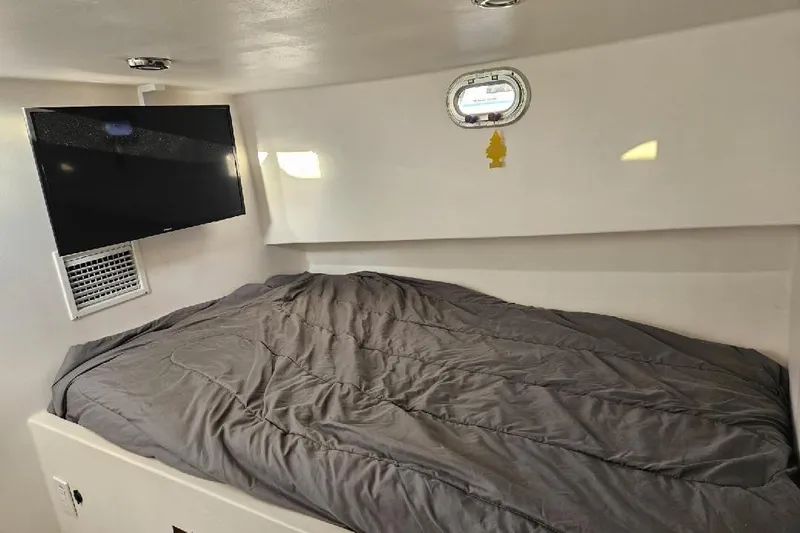 "silver Lining" Yacht Photos Pics Cozy boat cabin interior with bed, TV, and porthole, Flowers Down East 2022 model.
