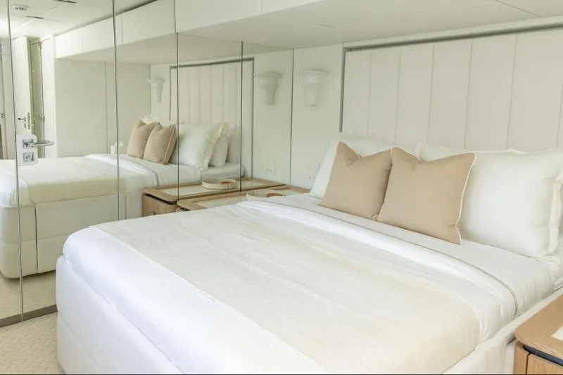 Fat Cat Yacht Photos Pics Luxurious bedroom interior on 2024 Sunreef 80 Power yacht with elegant bedding and mirrored walls.