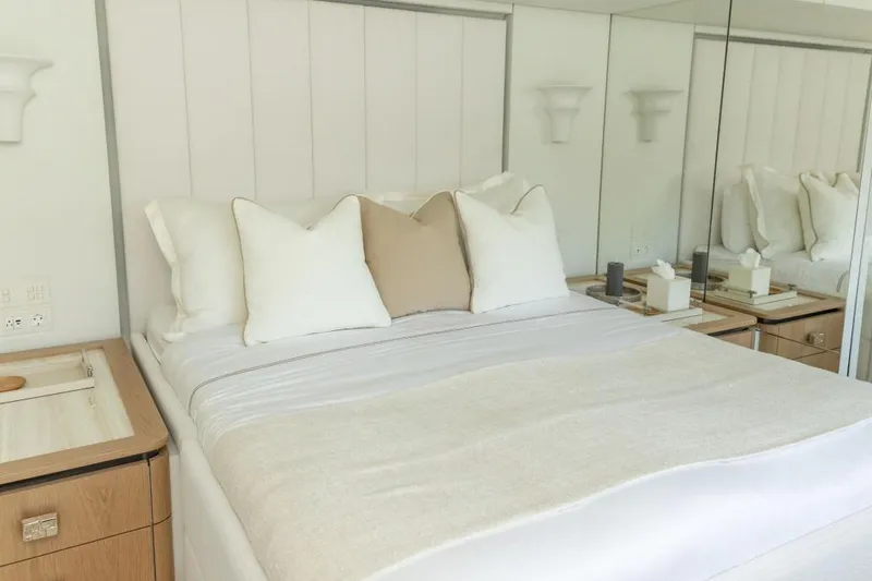 Fat Cat Yacht Photos Pics Luxurious bedroom interior on 2024 Sunreef 80 Power yacht, featuring elegant bedding and mirrored walls.