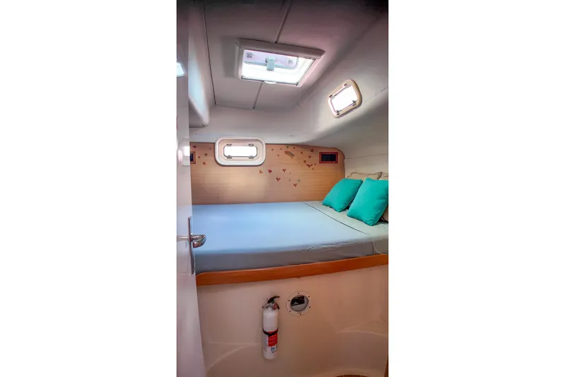 Katara Yacht Photos Pics Cozy cabin interior of 2005 Leopard 43 yacht with skylight and turquoise pillows.