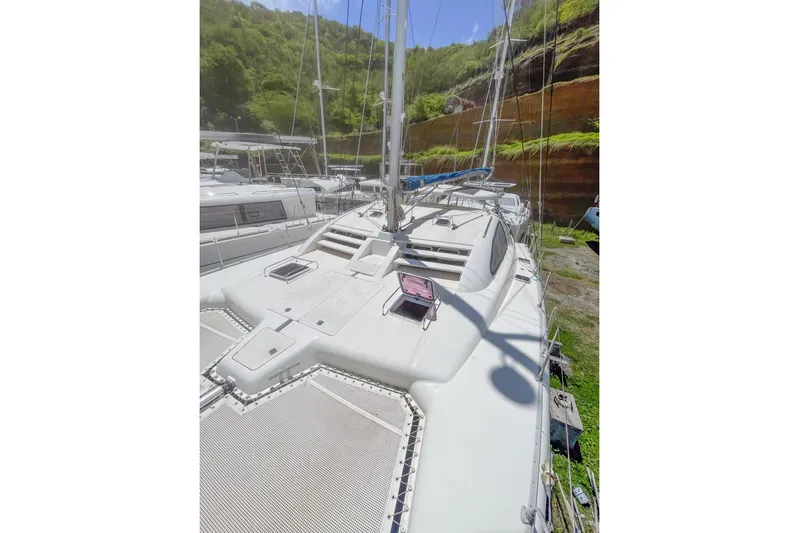 Katara Yacht Photos Pics 2005 Leopard 43 catamaran docked, showcasing deck and rigging against lush hillside backdrop.