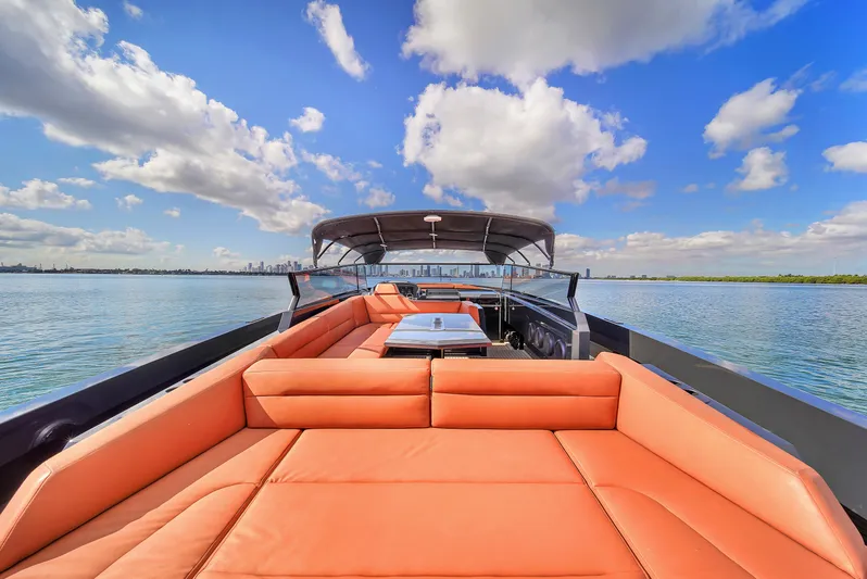  Yacht Photos Pics Luxurious 2020 Vanquish VQ58 yacht with orange seating, cruising on a sunny day.