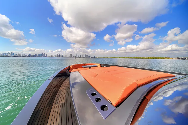  Yacht Photos Pics Luxurious 2020 Vanquish VQ58 yacht cruising on a sunny day with city skyline view.