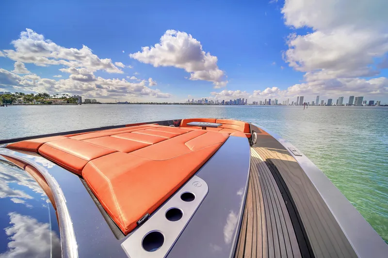  Yacht Photos Pics Luxury Vanquish VQ58 yacht with orange seating, city skyline, and blue sky.