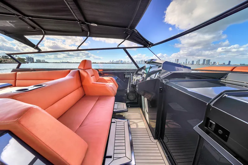 Yacht Photos Pics Luxurious 2020 Vanquish VQ58 yacht interior with orange seating and city skyline view.