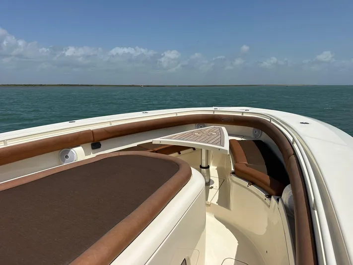  Yacht Photos Pics 2015 Scout 350 LXF boat interior with brown seating, table, and ocean view.