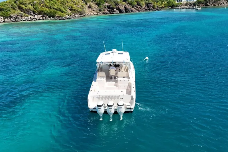 Yacht Photos Pics 2006 Grady-White Express 360 boat on clear blue water near a rocky shoreline.