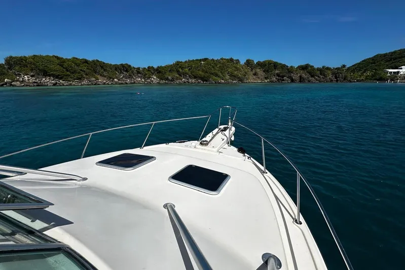  Yacht Photos Pics 2006 Grady-White Express 360 boat cruising in clear blue waters near lush green islands.
