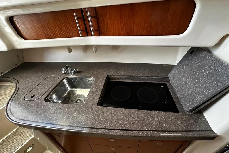  Yacht Photos Pics 2006 Grady-White Express 360 boat kitchen with sink and stove, featuring wood cabinetry.
