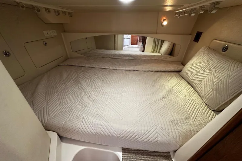  Yacht Photos Pics Cozy cabin interior of 2006 Grady-White Express 360 with quilted bedding and soft lighting.