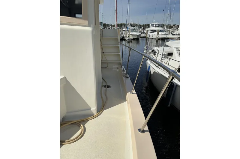  Yacht Photos Pics 2009 Hugh Huff Custom Pilothouse Trawler docked, showcasing deck and railing.
