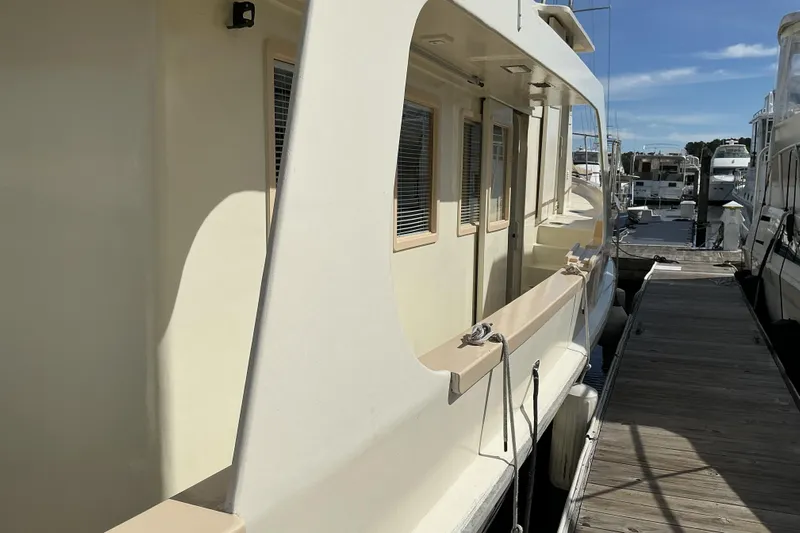  Yacht Photos Pics 2009 Hugh Huff Custom Pilothouse Trawler docked at marina under clear blue sky.