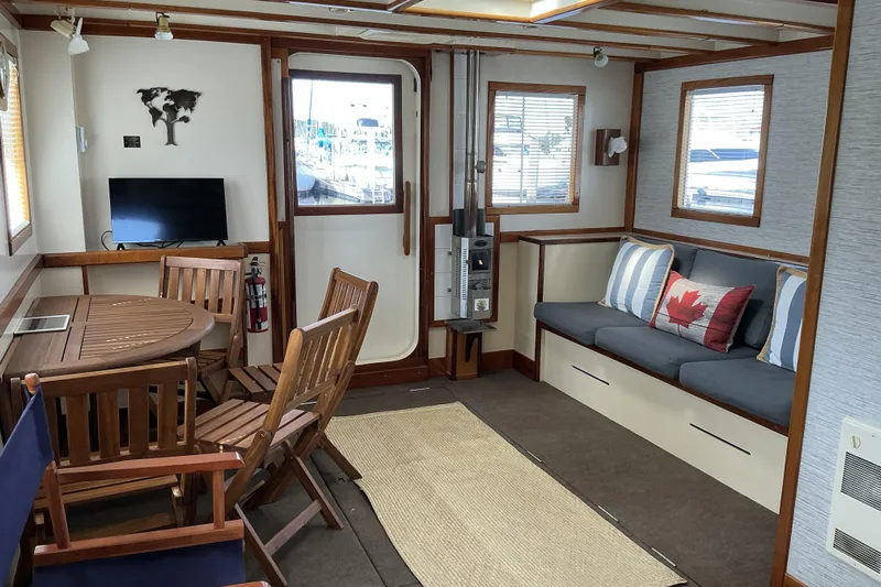  Yacht Photos Pics Interior of 2009 Hugh Huff Custom Pilothouse Trawler with cozy seating and wooden dining area.