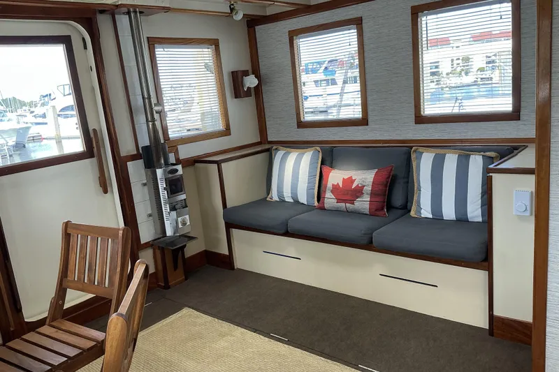  Yacht Photos Pics Cozy interior of 2009 Hugh Huff Custom Pilothouse Trawler with nautical decor and seating.