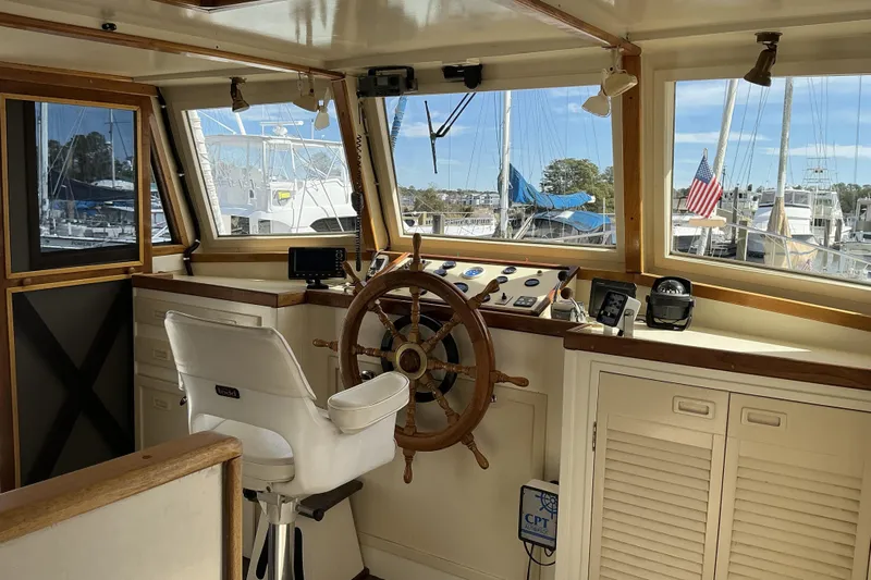  Yacht Photos Pics Pilothouse interior of 2009 Hugh Huff Custom Trawler with wooden wheel and navigation equipment.