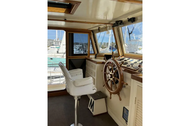 Yacht Photos Pics Pilothouse interior of 2009 Hugh Huff Custom Pilothouse Trawler with wooden steering wheel.