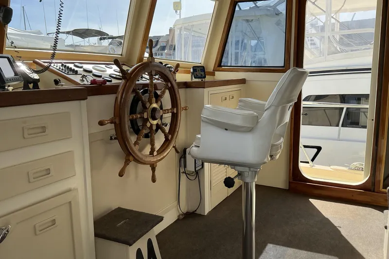  Yacht Photos Pics Pilothouse interior of 2009 Hugh Huff Custom Trawler with steering wheel and captain's chair.