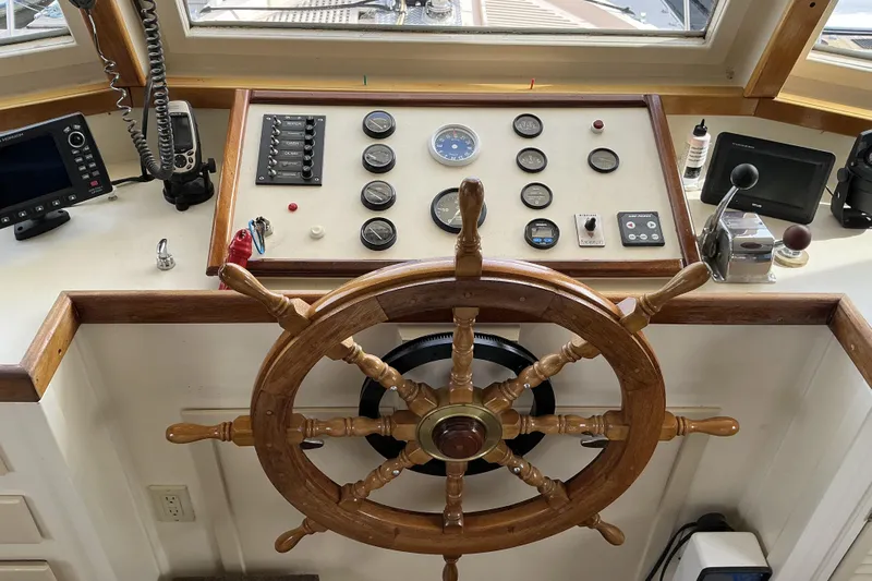  Yacht Photos Pics Pilothouse of 2009 Hugh Huff Custom Trawler with wooden wheel and navigation instruments.