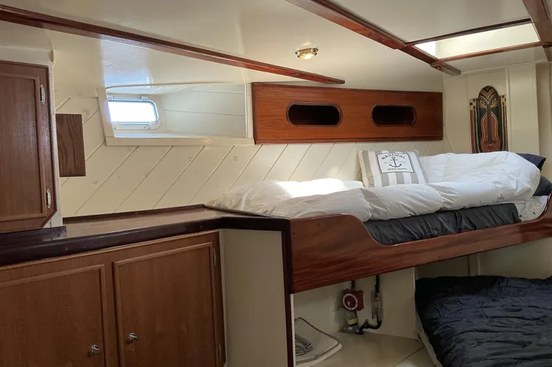  Yacht Photos Pics Cozy cabin interior of 2009 Hugh Huff Custom Pilothouse Trawler with wooden accents and bedding.