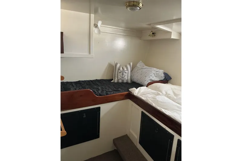  Yacht Photos Pics Cozy cabin interior of 2009 Hugh Huff Custom Pilothouse Trawler with nautical-themed pillows.
