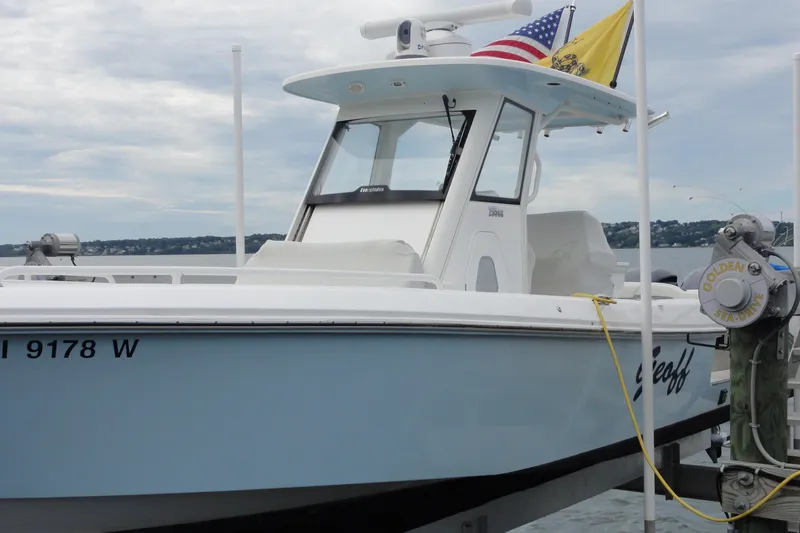  Yacht Photos Pics 2016 Everglades 295 Center Console boat docked with flags, cloudy sky background.
