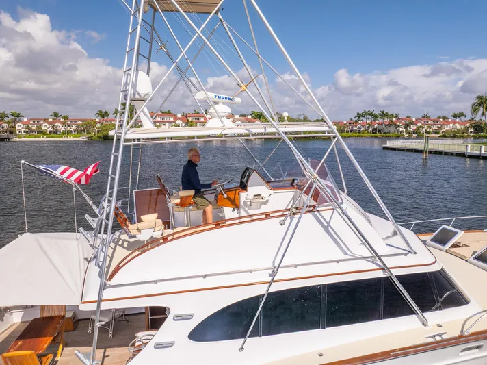 Ta-boo Yacht Photos Pics 1970 Rybovich 54 yacht on water, featuring a flybridge and American flag.