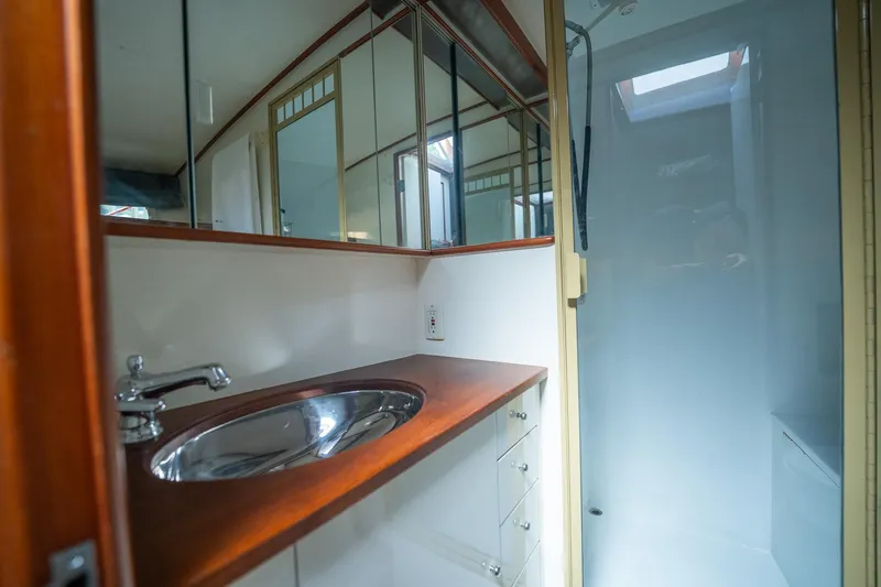 Ta-boo Yacht Photos Pics 1970 Rybovich 54 yacht bathroom with wooden countertop and stainless steel sink.