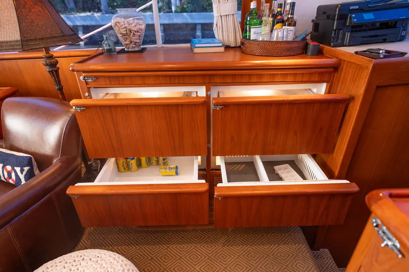 Ta-boo Yacht Photos Pics 1970 Rybovich 54 yacht interior with open wooden drawers and a well-stocked bar area.