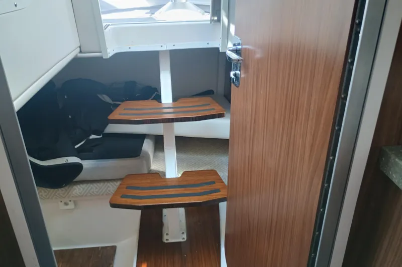 350-004 Brokerage Joe Yacht Photos Pics Interior cabin of 2019 Four Winns H350 OB boat with wooden steps and seating area.