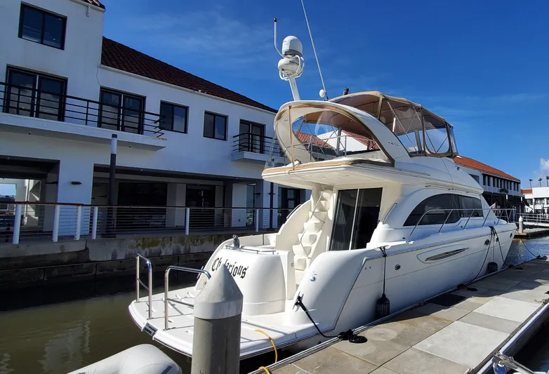 Chelarious Yacht Photos Pics 2005 Meridian 411 Sedan yacht docked at marina, sunny day, modern waterfront buildings.