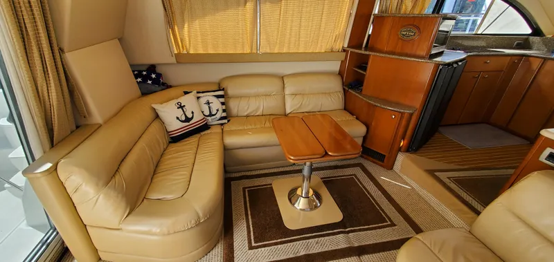 Chelarious Yacht Photos Pics Luxurious interior of a 2005 Meridian 411 Sedan yacht with beige leather seating.
