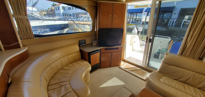 Chelarious Yacht Photos Pics Interior of 2005 Meridian 411 Sedan yacht with leather seating and TV, dockside view.