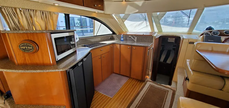 Chelarious Yacht Photos Pics Interior of a 2005 Meridian 411 Sedan yacht with kitchen and seating area.
