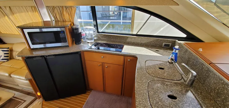 Chelarious Yacht Photos Pics Interior of 2005 Meridian 411 Sedan yacht kitchen with appliances and granite countertops.