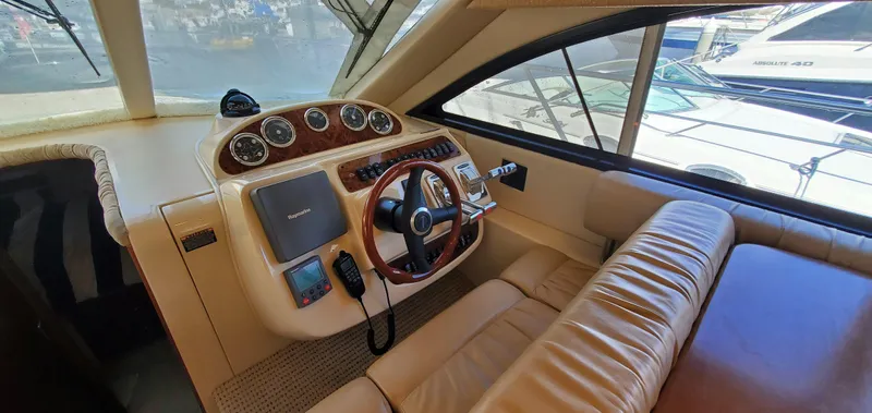Chelarious Yacht Photos Pics 2005 Meridian 411 Sedan helm with leather seating and wooden steering wheel.