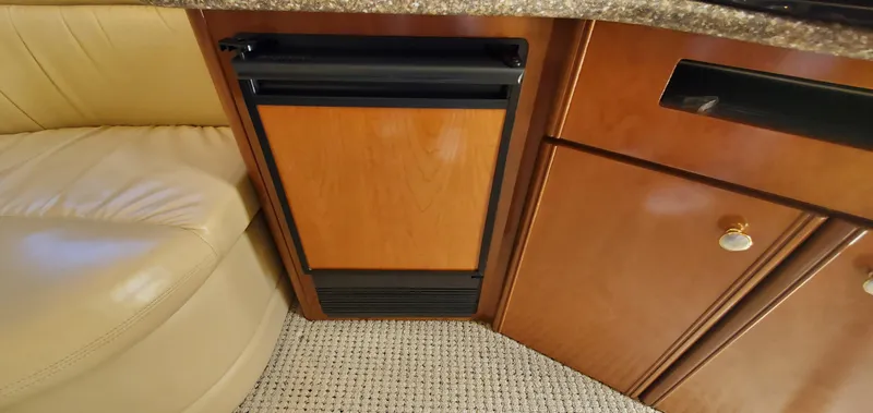 Chelarious Yacht Photos Pics 2005 Meridian 411 Sedan interior with wood cabinetry and beige seating.