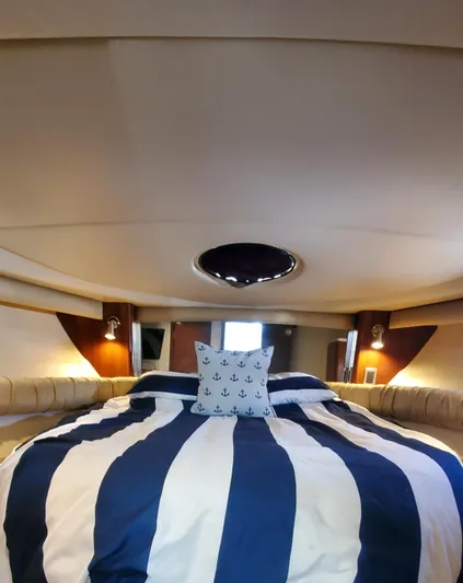 Chelarious Yacht Photos Pics Interior of 2005 Meridian 411 Sedan yacht with striped bedding and nautical-themed decor.